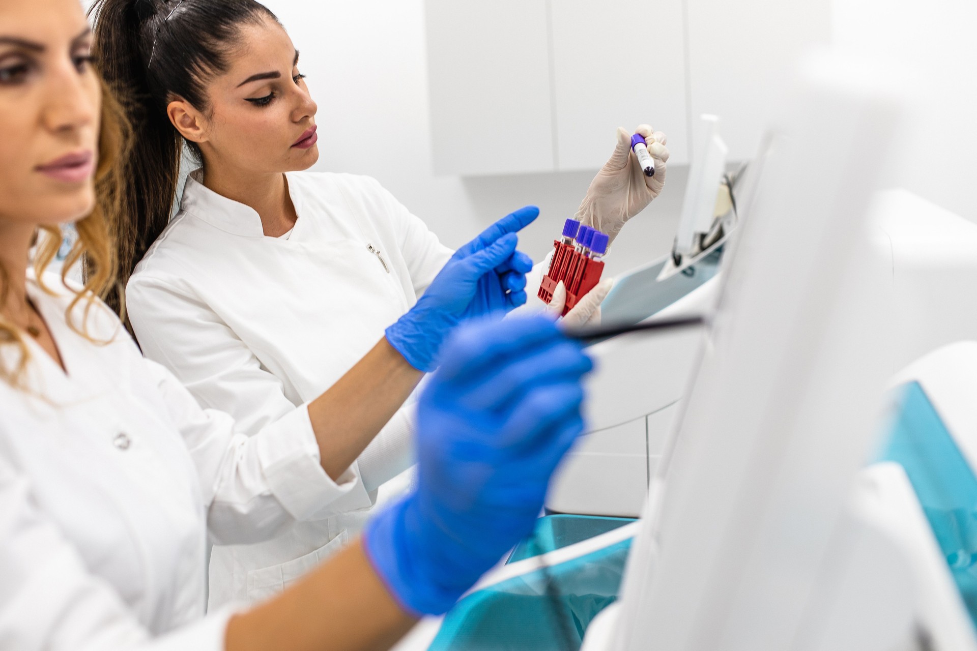 Scientists working with automated analyser in the laboratory
